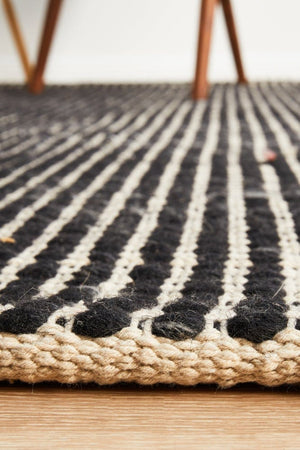 Navia Black flatweave rug — detail shot in dark contemporary interior