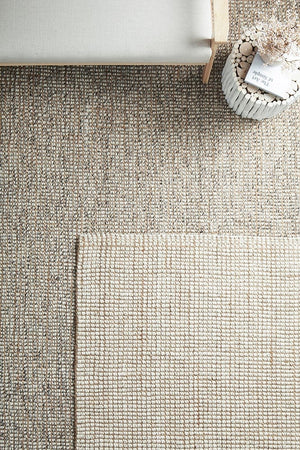 Scandi natural and grey wool jute rugs layered together in a living room
