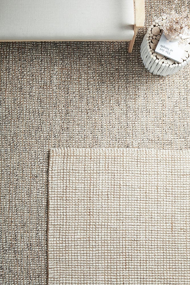 Scandi natural and grey wool jute rugs layered together in a living room