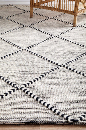 Jasmin flatwoven rug — black and ivory tones in a bedroom setting