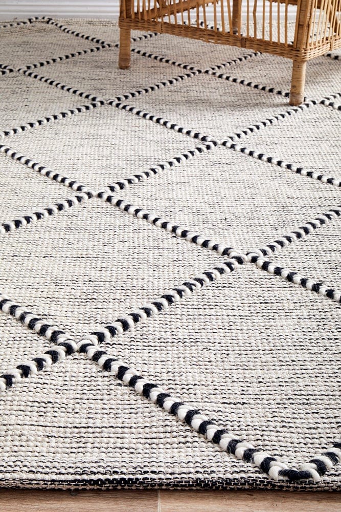 Jasmin flatwoven rug — black and ivory tones in a bedroom setting