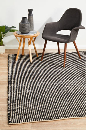 Navia Black flatweave wool rug — lifestyle shot in contemporary living room
