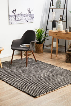Navia Black rug — top-down flat lay showing black flatweave texture