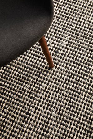 Navia Black rug — styled in open-plan living room with neutral furniture